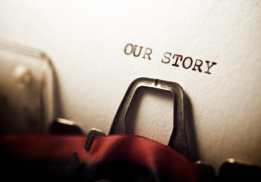 type writer showing 'our story' written out 