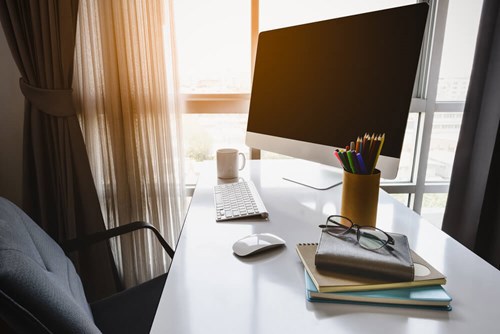 image of a desk top with a computer and stationary 