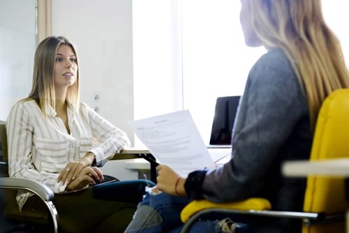 two women sat opposite each other having a conversation 