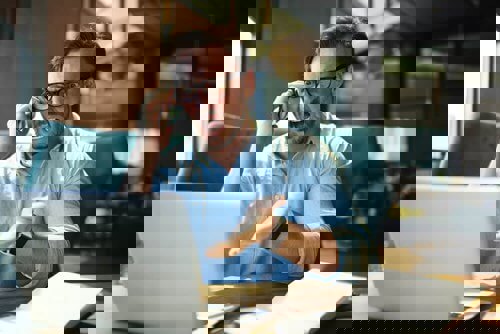 man looking very frustrated whilst on a phone call 