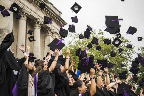 Graduates throwing caps up in the air