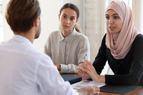 two female and one male colleague talking
