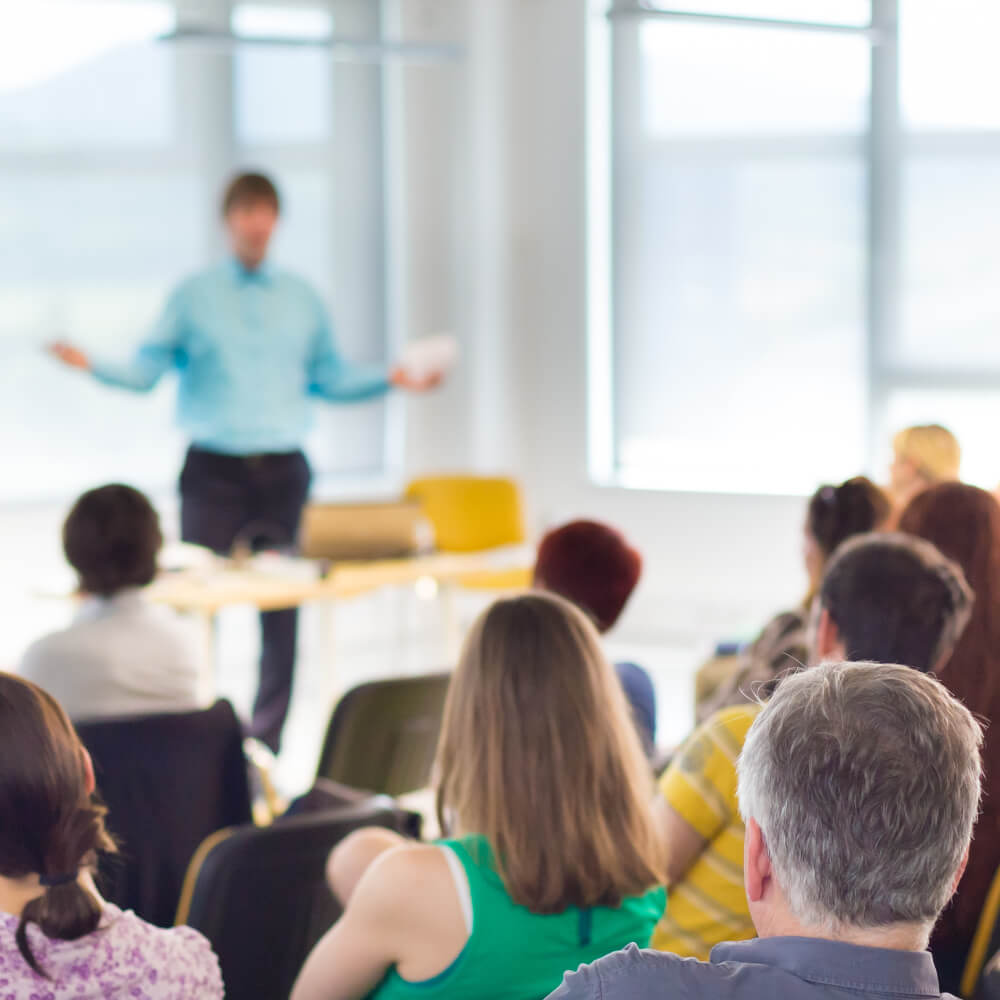 induction training course room full of people learning 
