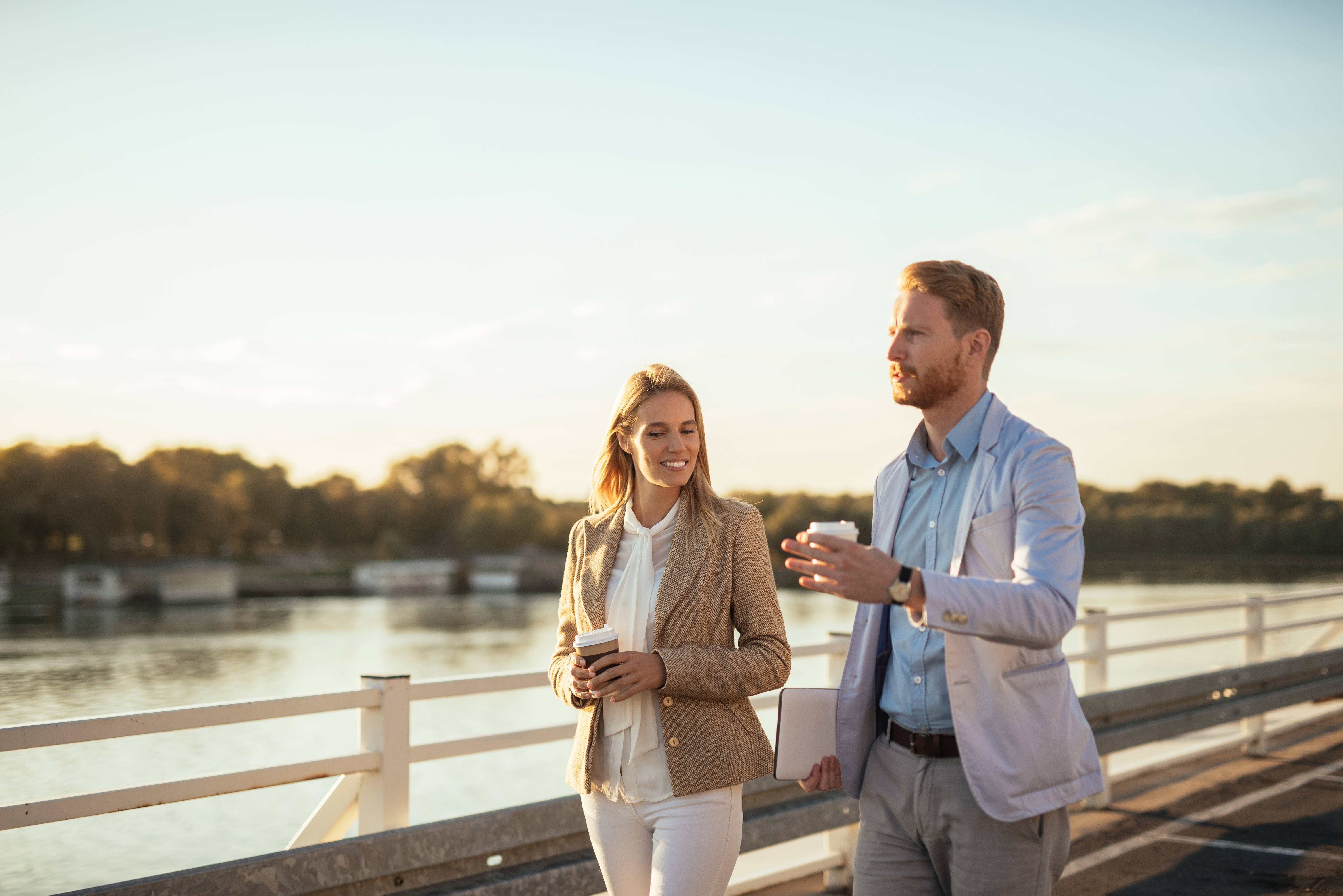 man and woman walking with a coffee 