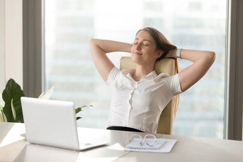 woman leaning back and relazing at her office desk 