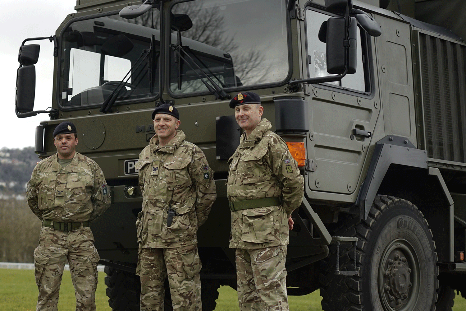 men in army uniform stood in front of truck
